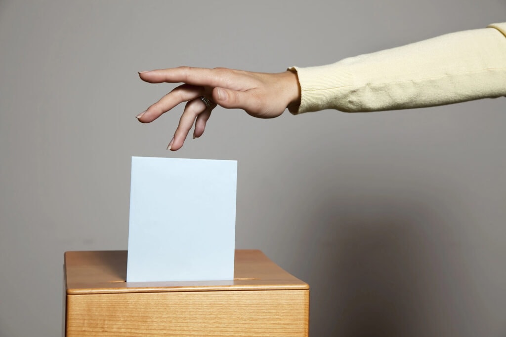 a young woman with a voter in the voting booth. voting in a democracy